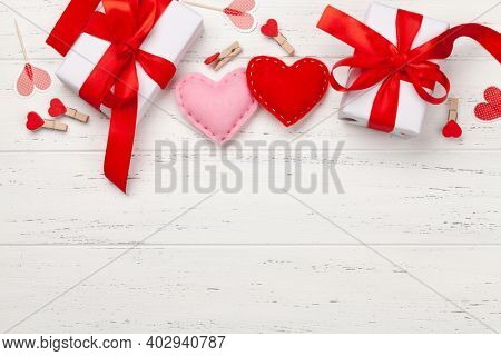 Valentines day greeting card template. Gift boxes and heart decor over wooden background. Top view flat lay with copy space