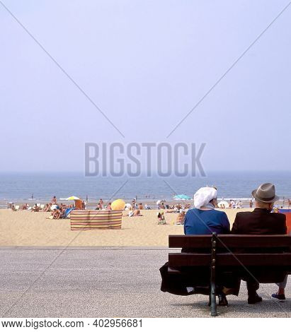 Scheveningen,holland-august 12,2008:people In Old Fashioned Dress Sitting On A Bench At The Boardwal