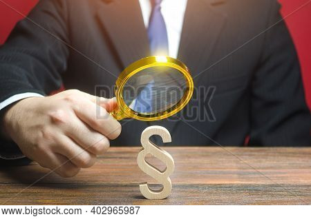 A Man Examines A Paragraph Stick Figure With A Magnifying Glass. Lawmaking And Legislation. Regulati
