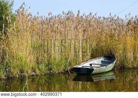 Boat In The Reeds On The Smooth Surface Of The Lake. Leningrad Region. Russia. September 2020