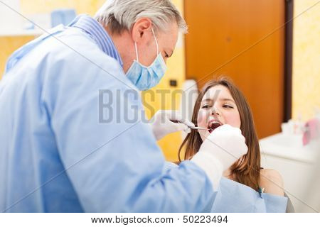 Dentist doing a dental treatment on a female patient