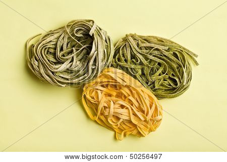 Italian pasta tagliatelle on color background
