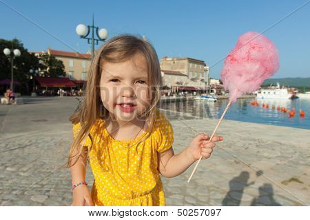 Pretty little girl eating candy floss
