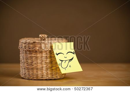 Drawn smiling face on a post-it note sticked on a jewelry box