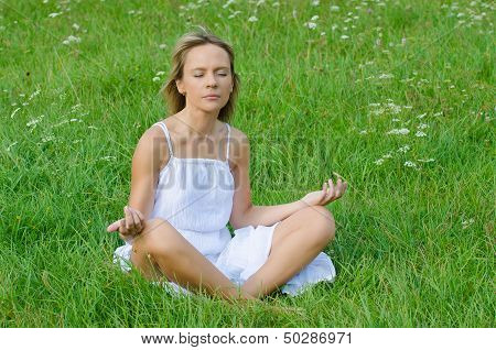 young woman practicing yoga in nature