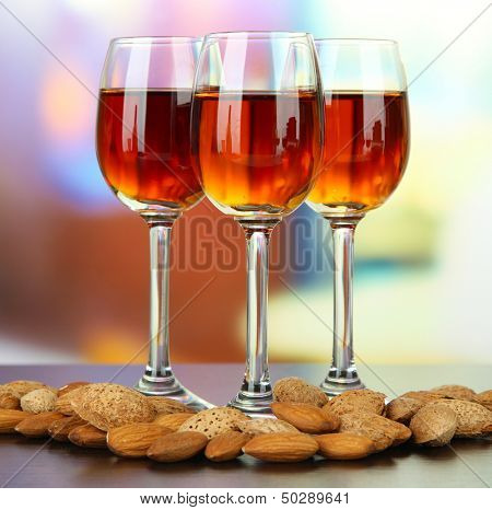 Sklenice likéru amaretto a pražených mandlí, na světlé pozadí