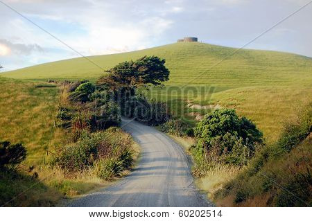 Gravel Road Turn Left At Rural Area Near Water Tank On Hill Top