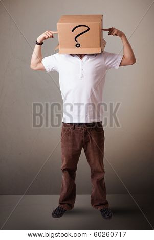 Young man standing and gesturing with a cardboard box on his head with question mark