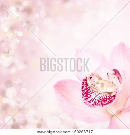 Pink orchid and golden wedding rings
