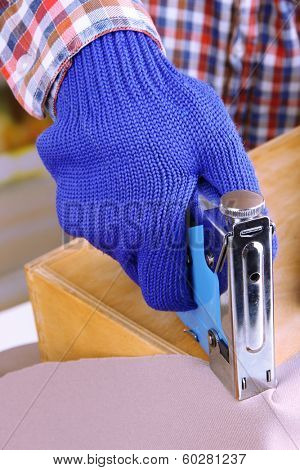 Fastening fabric and wooden box using construction stapler close up