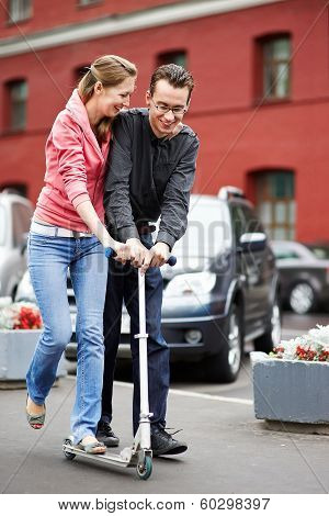 Happy Couple With Scooter On City Street