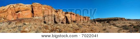 Aztec Ruins against red rock cliffs