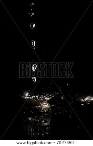 Water Droplets Splashing Onto A Black Surface