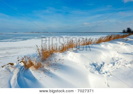 Śnieg wydm nad jeziorem w zimie