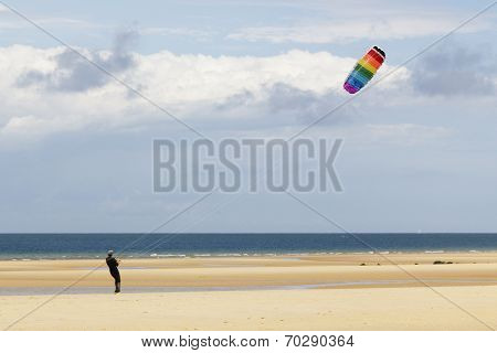 Man playing with a kite at the beach