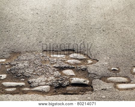 Cutting Of An Old Road With Cracked Asphalt And A Gully In The Center Of Cobblestones