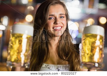Smiling oktoberfest barmaid with beer at the bar