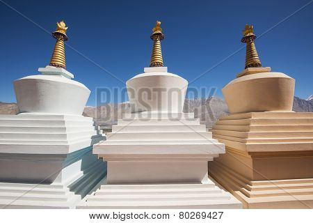 Three stupa and blue sky at Diskit monastery, Ladakh, India - September 2014