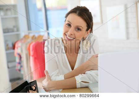 Beautiful shopgirl working in clothing store