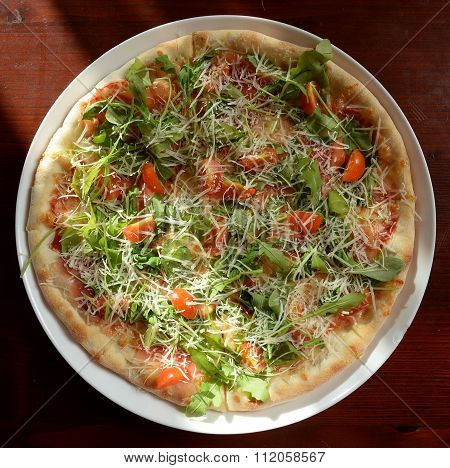 Pizza with rucola , ham and cherry tomato