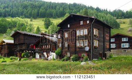 The ancient traditional chalet and Church along the Furkastrasse. Floral decoration on the facades i