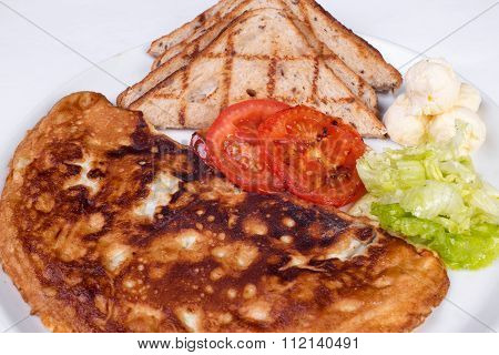 English breakfast with scrambled eggs, tomatoes, potatoes, toast and fresh salad