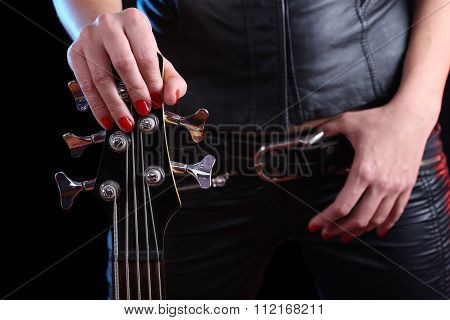 Sexy girl in leather clothes with bass guitar