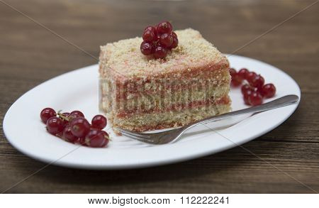 Fresh delicious diet cake with berry red currant at Dukan Diet on a porcelain plate with a spoon on a wooden background