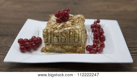 Fresh delicious diet cake with berry red currant at Dukan Diet on a porcelain plate with a spoon on a wooden background
