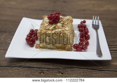 Fresh delicious diet cake with berry red currant at Dukan Diet on a porcelain plate with a spoon on a wooden background