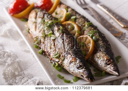 Fish Saury Grilled With Lemon And Chives On A Plate Close-up. Horizontal