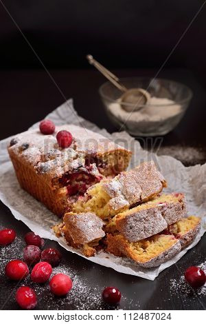 Cut Cranberry Muffin Against A Dark Background With Powdered Sugar And Cranberries