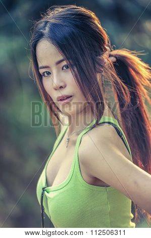 Asia Young Woman Wearing Green Vest On Park