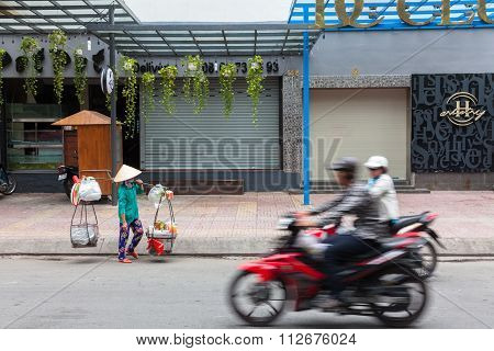 Street food vendor in traditional conical hat
