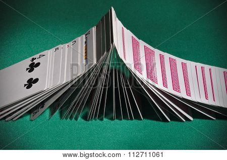 Poker playing cards turning face-up sequentially like dominoes