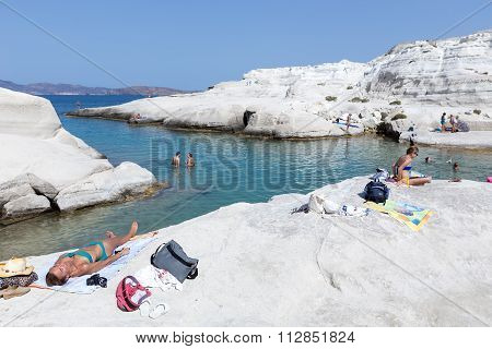 Tourists Enjoy The Clear Water Of Sarakiniko Beach In Milos, Greece. This Beach Is One Of The Most B