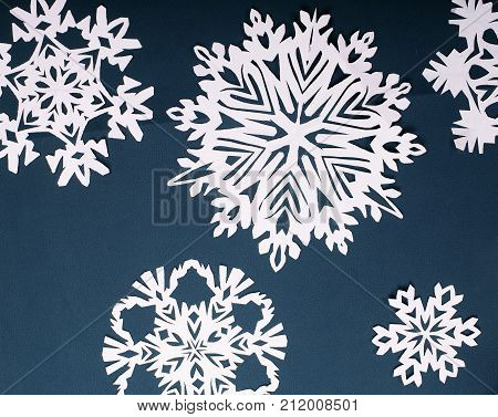 Winter style background.Paper snow flakes on blue background