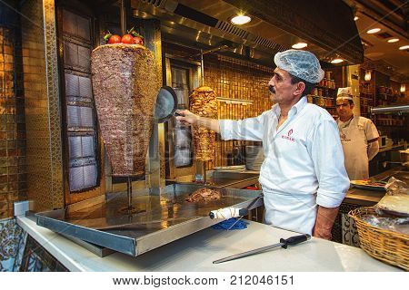 ISTANBUL, TURKEY: A chef cutting traditional Turkish food Doner Kebab in a street food shop on October 6, 2017