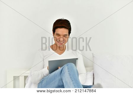 Men are playing mobile in the bedroom.