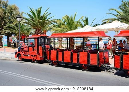 RETHYMNO, CRETE - SEPTEMBER 15, 2016 - Tourists aboard a red land train along the promenade Rethymno Crete Greece Europe, sEPTEMBER 15, 2016.