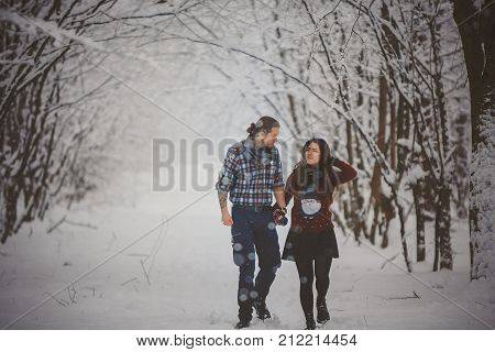 Young Happy Couple Walking in Winter Park