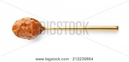 Spoon with delicious caramel sauce on white background