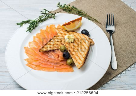 Smoked salmon with fresh dill on bread slice, in natural light, authentic food.