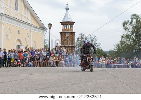 Verkhovazhye, Vologda region, Russia - August 9, 2014: Motorcycle Show on Cathedral Square in Verkhovazhye, Vologda region, Russia. Alexei Kalinin professional stantrayder. Champion of the Baltic States in 2005 Bronze medalist of the Baltic States in 2006