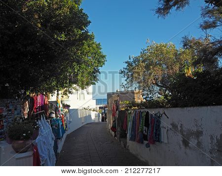 ITALY STROMBOLI JUNE 2 2016: Street leading to port at Stromboli with colorful selling clothes hanging from the surrounding walls