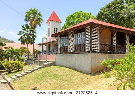 Side view of Deshaies church and surrounding buildings, set of tv movie Death in Paradise, Guadeloupe
