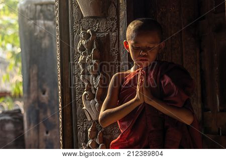 Buddhist novice praying at Shwenandaw pagoda mandalay myanmar