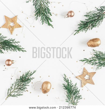Christmas composition. Christmas frame made of conifer branches balls golden decorations on white background. Flat lay top view copy space square