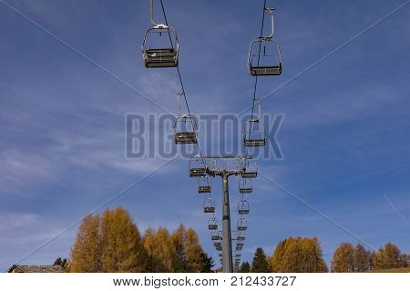 Chairlift without people. The cable car on the blue sky in the Dolomites. Cableway in the mountains without people