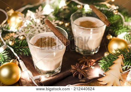 Traditional Winter Eggnog With Milk Rum and Cinnamon Sprinkle with Grated Nutmeg for Christmas Eve and Winter Holidays. Selective Focus
